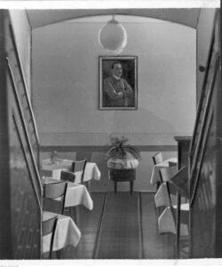 Hotel Reichshof - fragment wnętrza. Widoczna sala ze stolikami. Na ścianie portret Adolfa Hitlera 1940-12