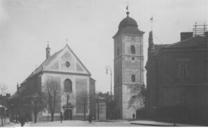 Kościół Farny Świętych Wojciecha i Stanisława. Widok zewnętrzny kościoła wraz z najstarszą budowlą miasta dzwonnicą 1918-1939
